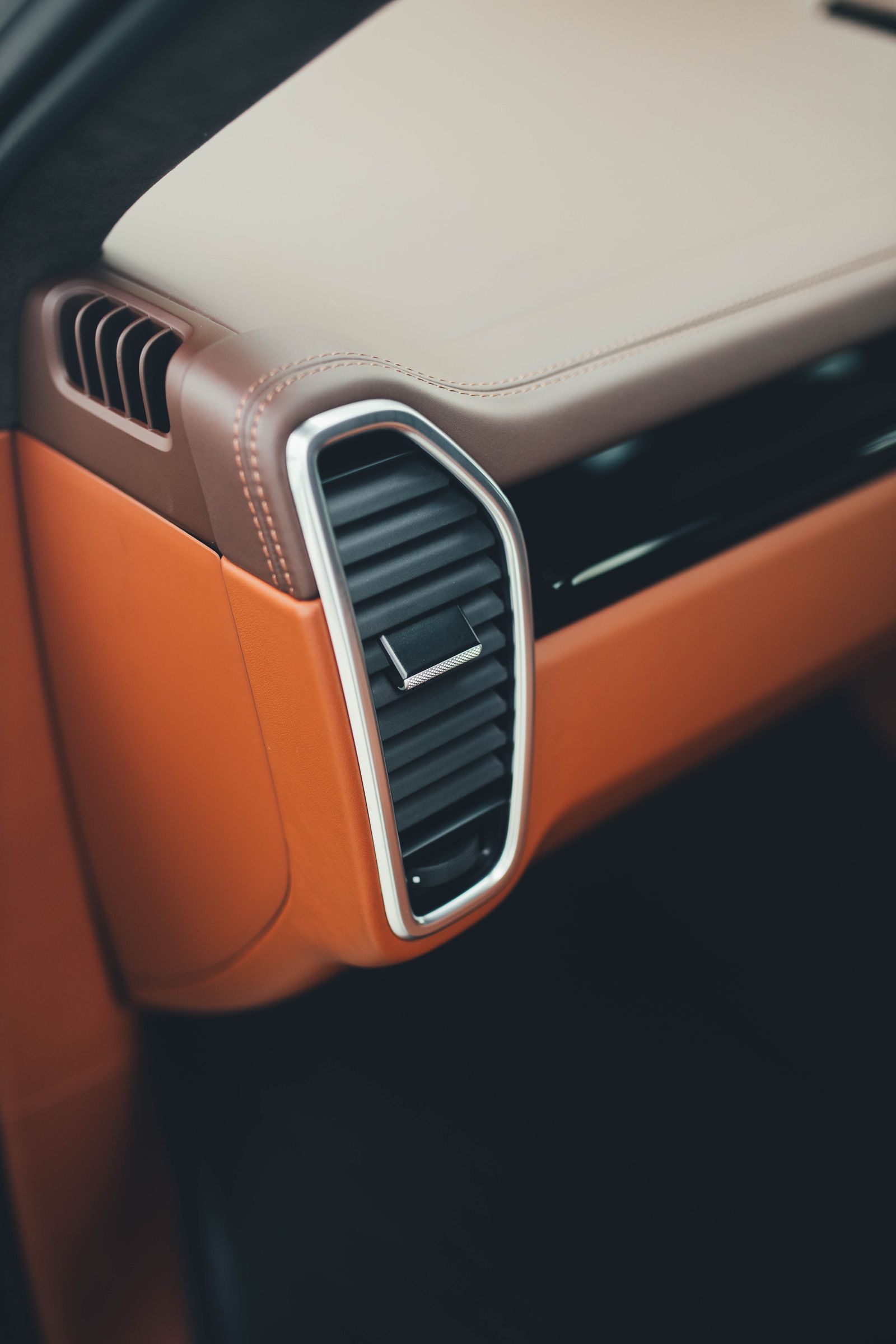Detailed tan leather and polished trim inside a luxury vehicle