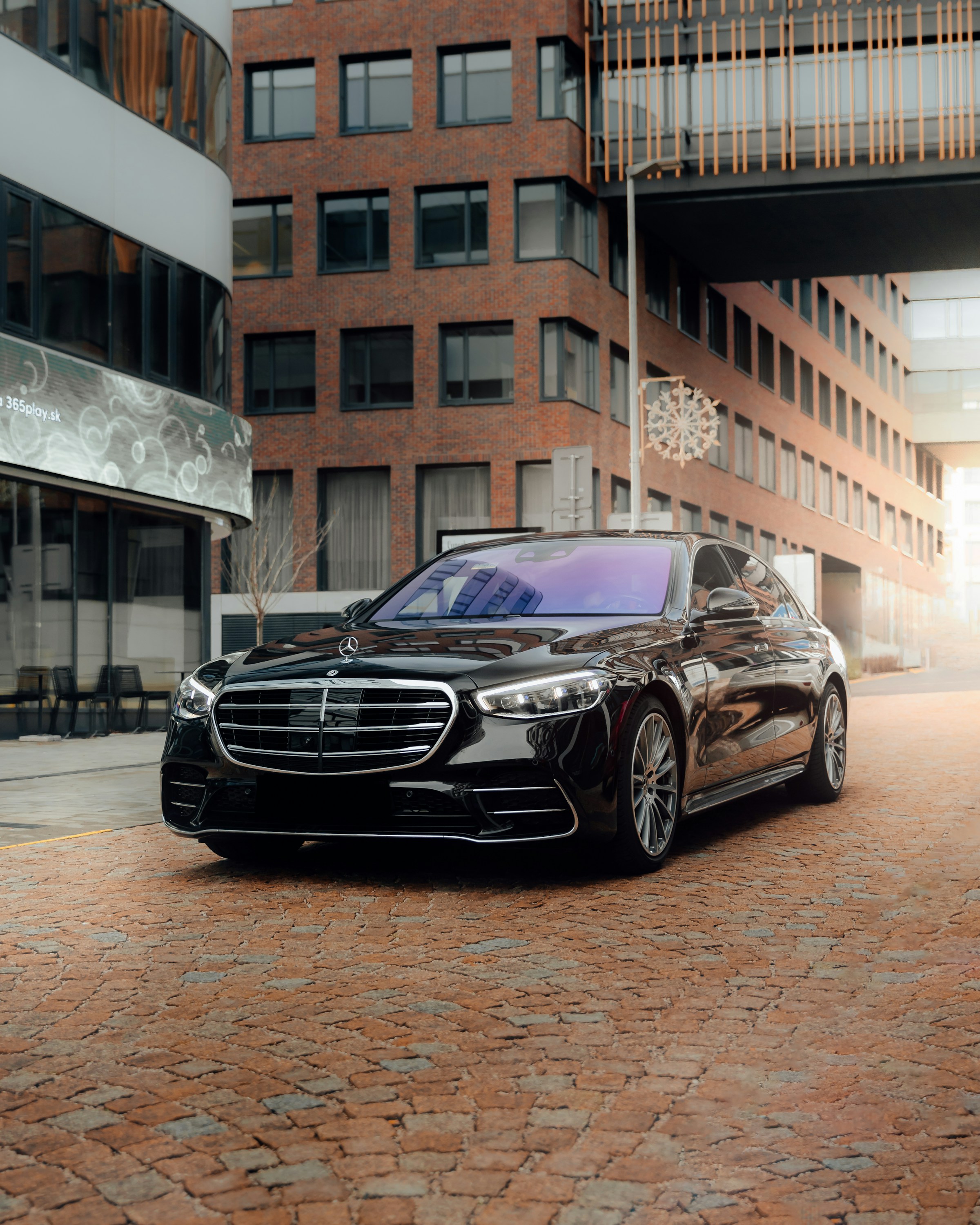 Black luxury sedan outside an elegant brick building